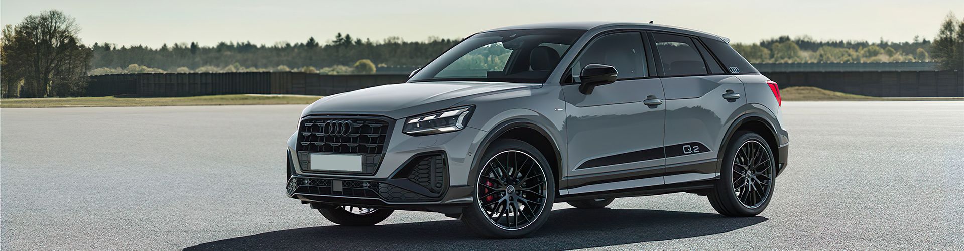 Audi Q2 on a broad parking with a forest
