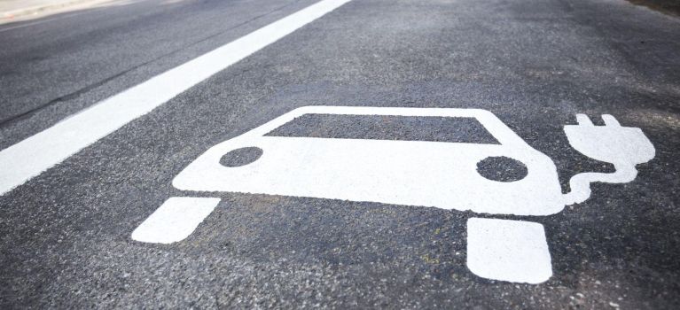 Symbol eines Elektroautos auf einer Straße