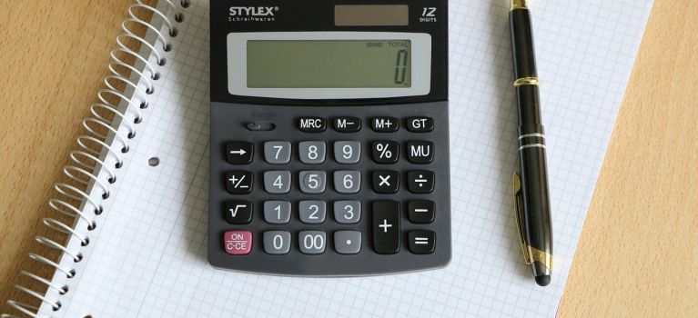 Calculator on paper with pen.