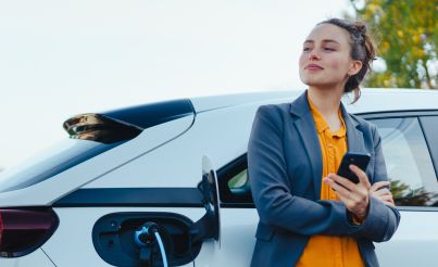 Woman with phone and electric car