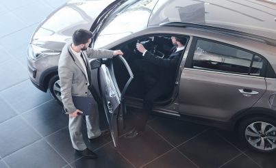 Mann im Gespräch mit einem anderen Mann beim Testen eines Autos